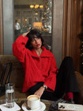 Woman wearing a red textured knit half-zip sweater and black pants, posing indoors.