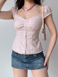 Woman wearing a pink striped floral print top with puff sleeves and a ruffled hem.