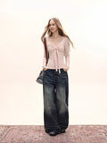 Model in a brown long sleeve tie front top with jeans