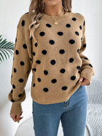 Close-up of a woman's torso wearing a tan polka dot sweater with visible knit texture.