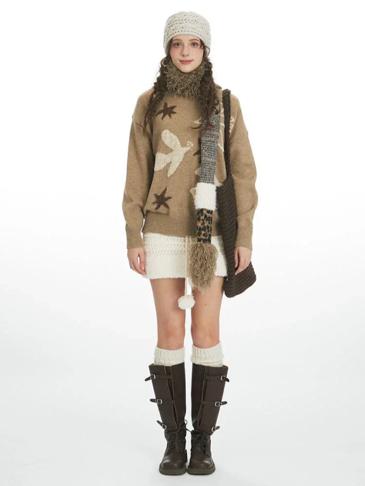 Woman wearing a tan intarsia knit sweater with birds and stars, a white textured mini skirt, white knee-high socks, and dark brown boots. Main image