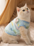 Side view of cat wearing light blue fleece vest with cartoon print