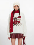 Model posing in a cream fuzzy knit sweater with a festive teddy bear design