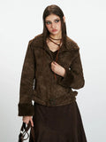 Close-up of a woman wearing a brown faux suede jacket with shearling collar and cuffs.