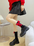 Woman wearing black crew socks with red bow accents