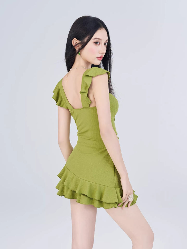 Rear view of a woman in a lime green mini dress showcasing the back straps and ruffled hem.