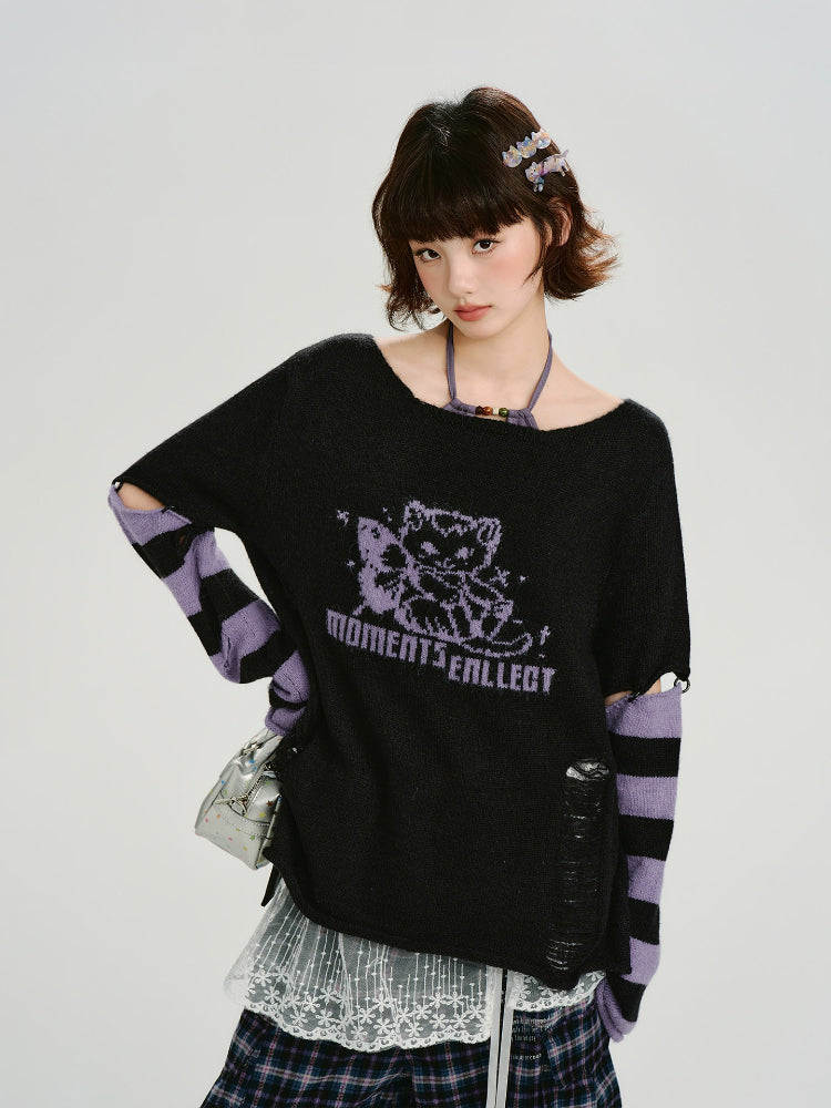 Woman wearing a black oversized knit sweater with a purple graphic print and distressed details.