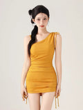 Woman wearing a yellow one-shoulder ribbed knit bodysuit with adjustable drawstring details