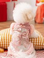Rear view of a white dog wearing a pink dog coat with traditional Chinese style closure and floral embroidery