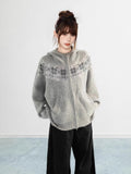 Side view of a woman wearing a black Fair Isle knit hoodie with front pockets