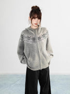 Side view of a woman wearing a black Fair Isle knit hoodie with front pockets