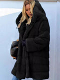 Woman wearing a black hooded faux fur coat with horizontal paneling.