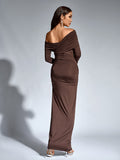 Back view of a woman in a brown long-sleeve one-shoulder draped maxi dress