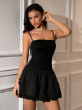Woman wearing a black cami mini dress with a ruffled skirt.