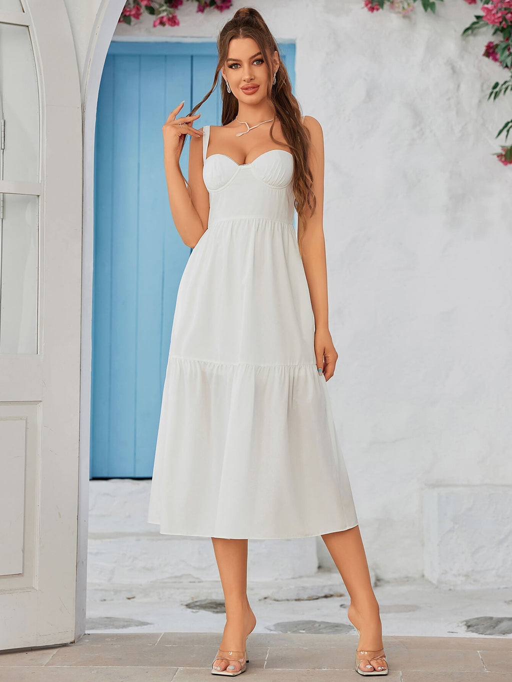 Rear side profile of a woman in a black crepe sheath dress with a sweetheart neckline.