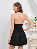 Back view of a woman in a black halter neck pleated dress.