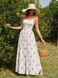 Woman in a white floral print maxi dress and a straw hat, picking oranges from a tree.