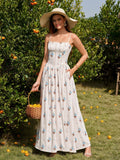 Woman wearing a white floral print maxi dress and a straw hat, holding a basket of oranges in an orchard.