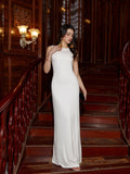 Woman in a white elegant dress holding a black clutch on a staircase