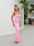Woman posing in a pink ruched mermaid maxi dress
