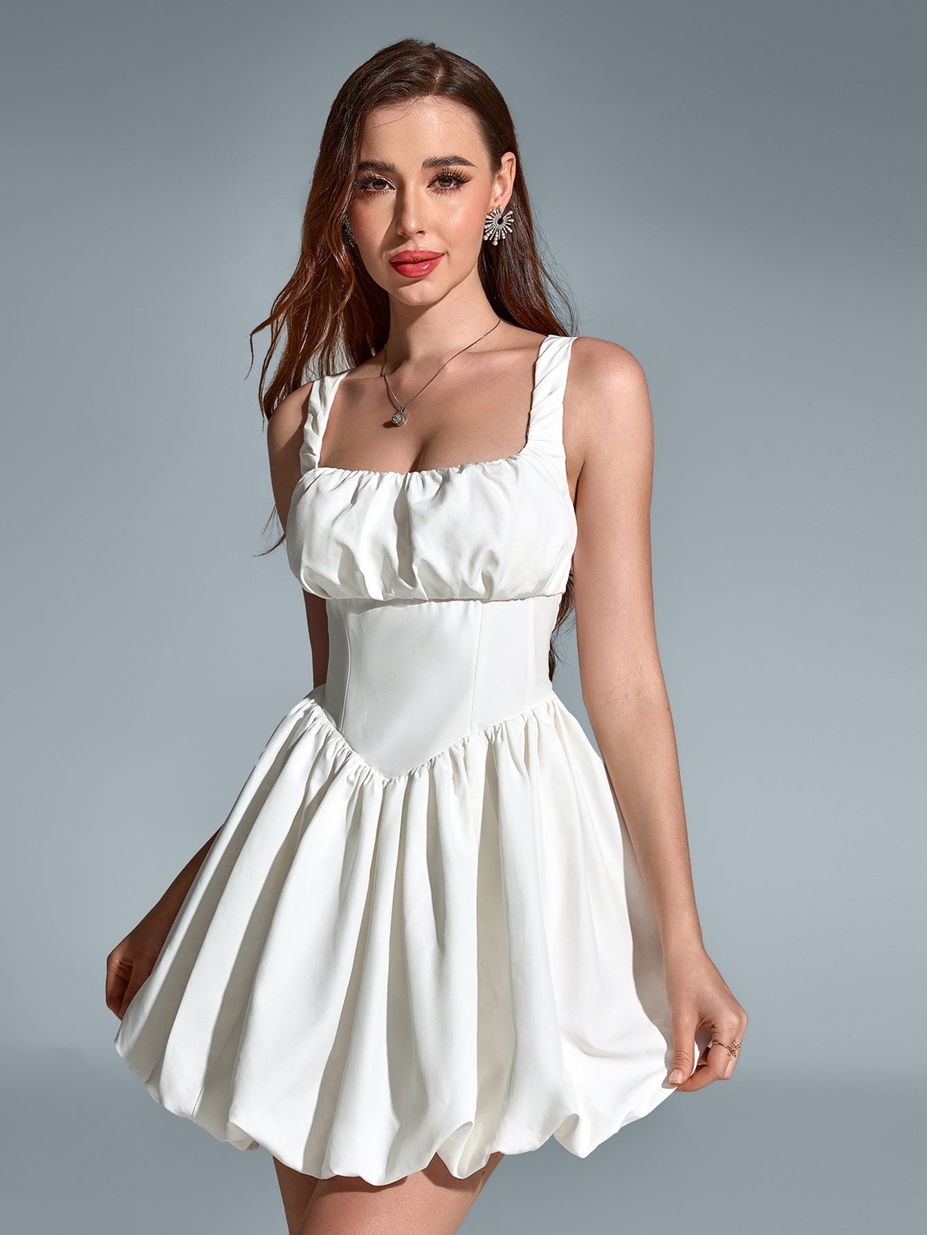 Model posing in a white square neck balloon hem dress