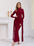 Woman wearing a long red formal dress with sheer sleeves and draping chiffon panels.