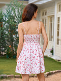 Rear view of a woman in a white floral print dress with a smocked back bodice and tiered skirt.