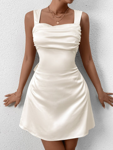 Model wearing a cream satin ruched mini dress with a square neckline and adjustable straps.