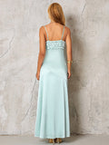 back view of a woman in a light blue satin maxi dress with spaghetti straps and an asymmetrical skirt detail