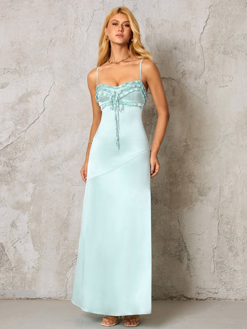 woman wearing a light blue satin maxi dress with spaghetti straps and a ruched, tie-front neckline