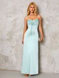 woman in a light blue satin maxi dress holding a gold clutch