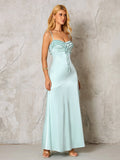 woman in a light blue satin slip dress with spaghetti straps and a ruched, tie-front bodice