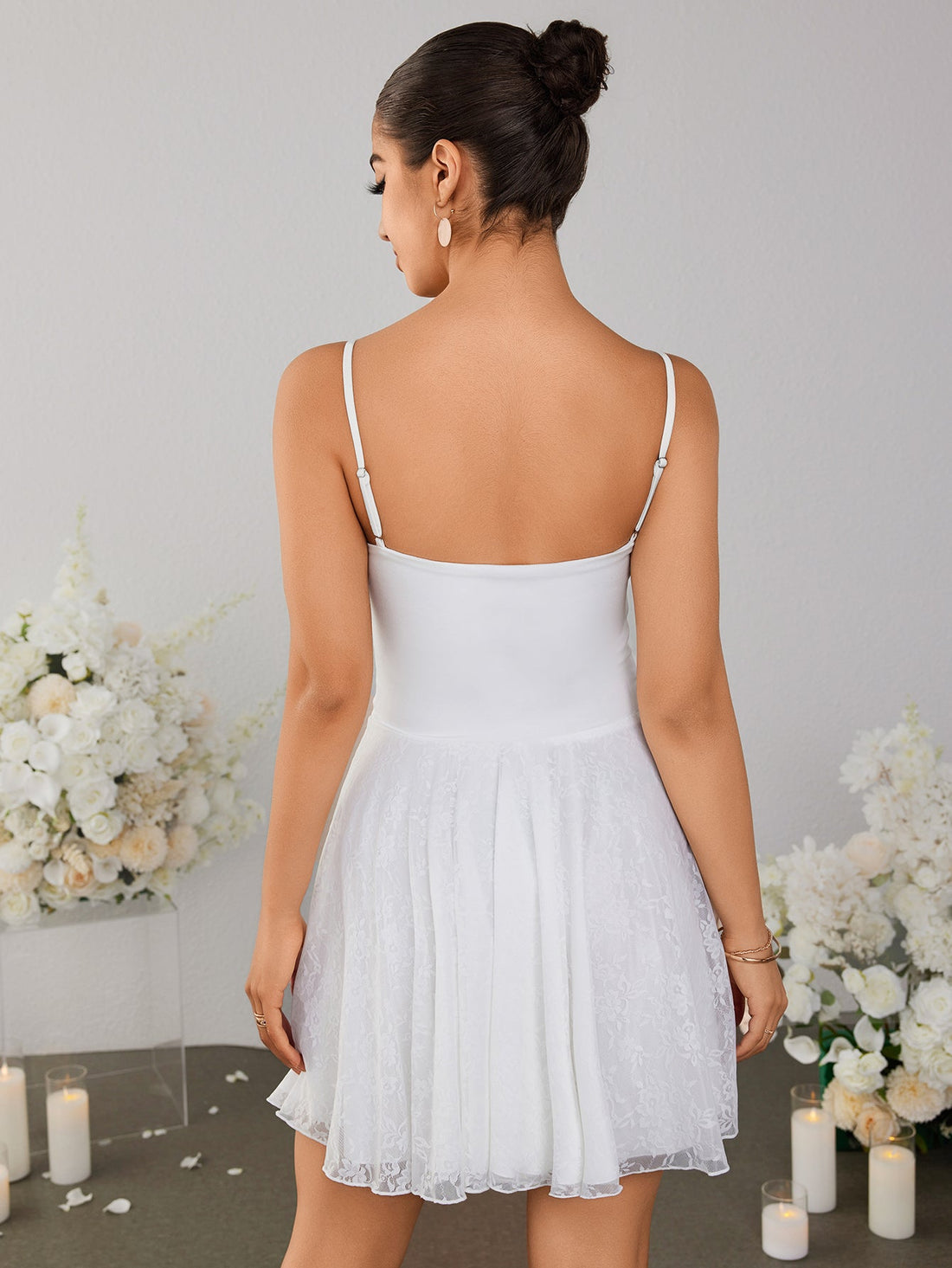 Model wearing a white lace mini dress with a square neckline and spaghetti straps