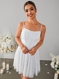 Close-up of a woman wearing a white lace mini dress with a square neckline