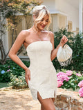 Woman in a white strapless textured floral bodycon dress holding a beaded clutch