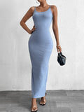 Woman in a blue shimmer knit bodycon maxi dress with cami straps and a scoop neckline, holding a black handbag.