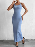 Woman in a blue shimmer knit bodycon maxi dress with cami straps and a scoop neckline, posing with her hand on her chin.