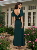 Back view of a woman in a dark green maxi dress with an open back and bow detail