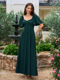 Full-length shot of a woman in a dark green evening gown