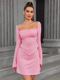 Woman wearing a pink long-sleeve top and skirt set with a square neckline and lace trim.