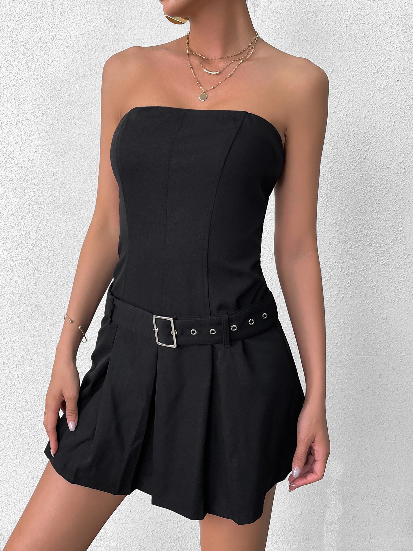 Close-up of a woman in a black strapless dress with a buckle belt