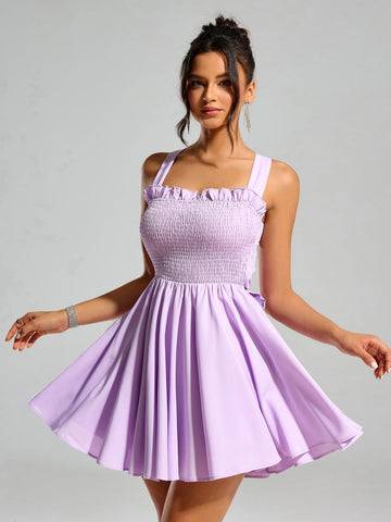 Woman wearing a lavender smocked mini dress with ruffle trim and square neckline