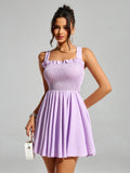 Woman posing in a lavender smocked mini dress, showcasing the flared skirt