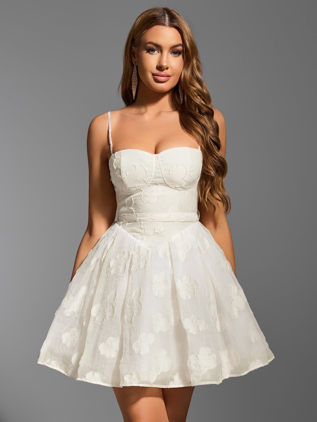 Woman wearing white embroidered floral sweetheart neckline spaghetti strap fit and flare dress smiling
