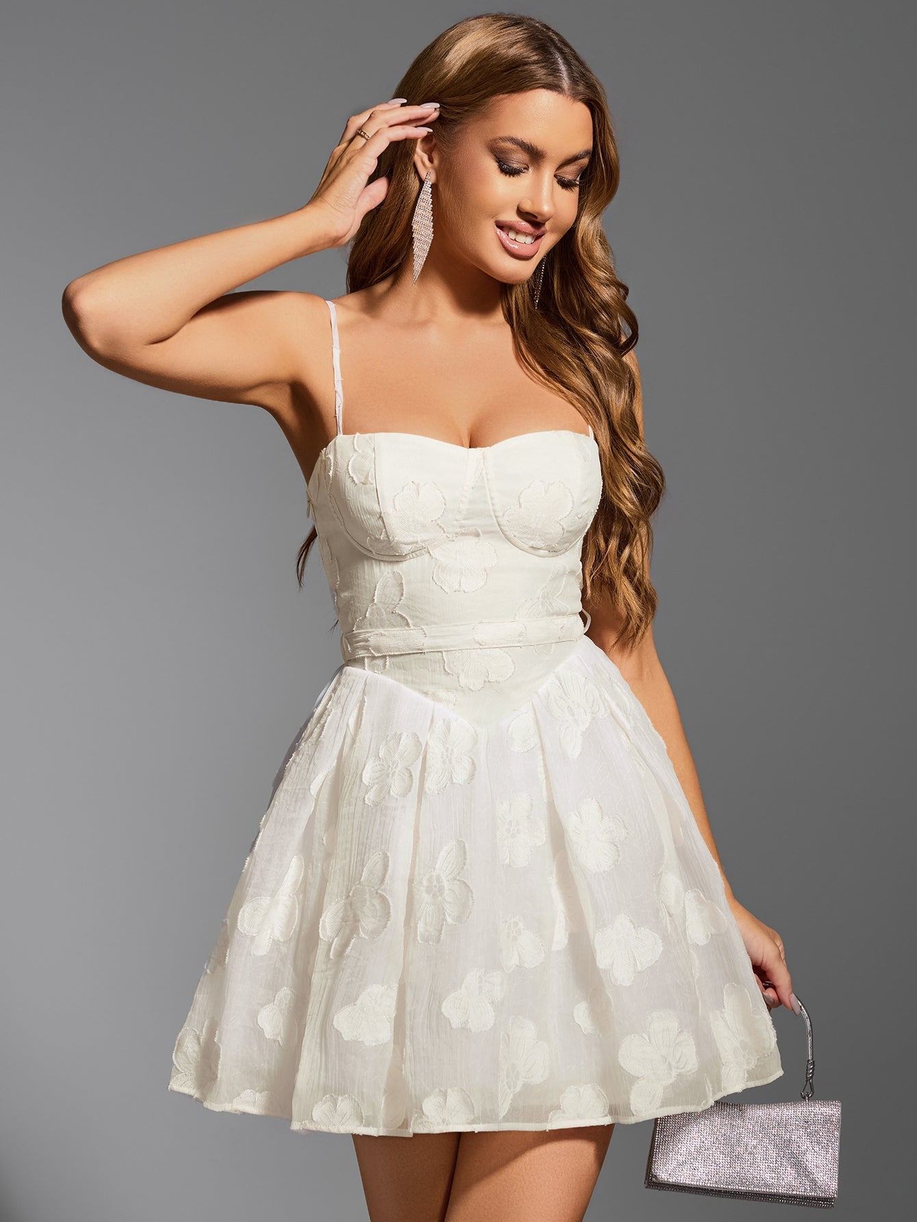 Woman wearing white embroidered floral sweetheart neckline spaghetti strap fit and flare dress posing with hand on head