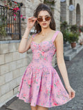 Woman wearing a pink floral print mini dress with a sweetheart neckline and thin straps.