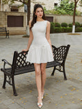 Full body shot of a woman in a white sleeveless A-line dress with a round neckline and tiered skirt, standing next to a bench.