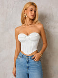 Woman wearing a white strapless corset top and blue denim jeans, front view