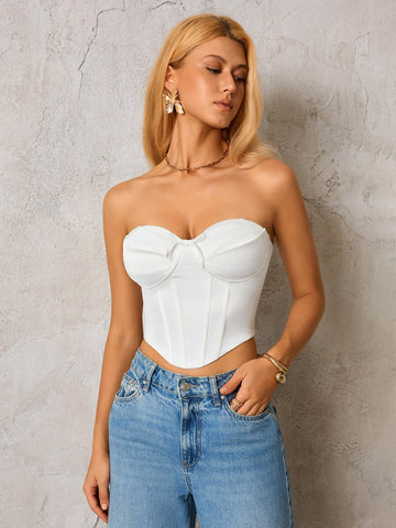 Woman wearing a white strapless corset top and blue denim jeans, front view
