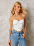 Woman wearing a white strapless corset top and blue denim jeans, looking to the side